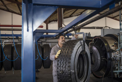 Tire repairer hanging new tire on hook