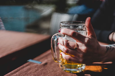 Close-up of man drinking glass on table