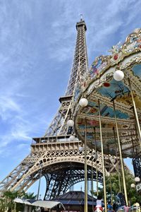 Low angle view of ferris wheel against cloudy sky