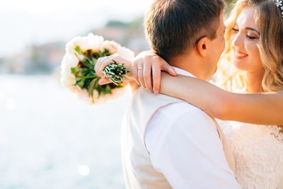 Close-up of couple holding flower bouquet