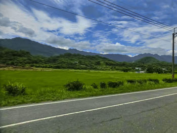 Road by mountains against sky