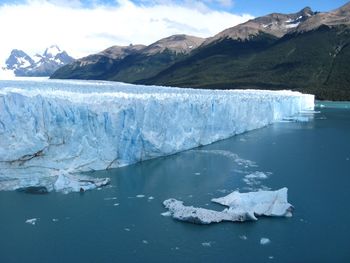 Scenic view of lake and snowcapped mountains against sky