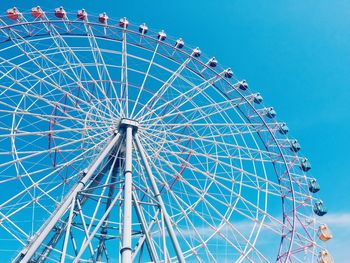 Low angle view of ferris wheel against blue sky