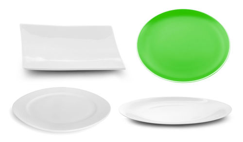 Close-up of empty plate on table against white background