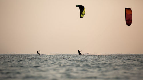 People on sea against clear sky