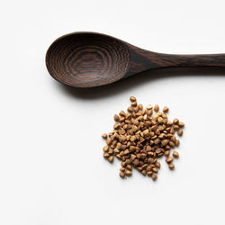 High angle view of roasted coffee beans against white background