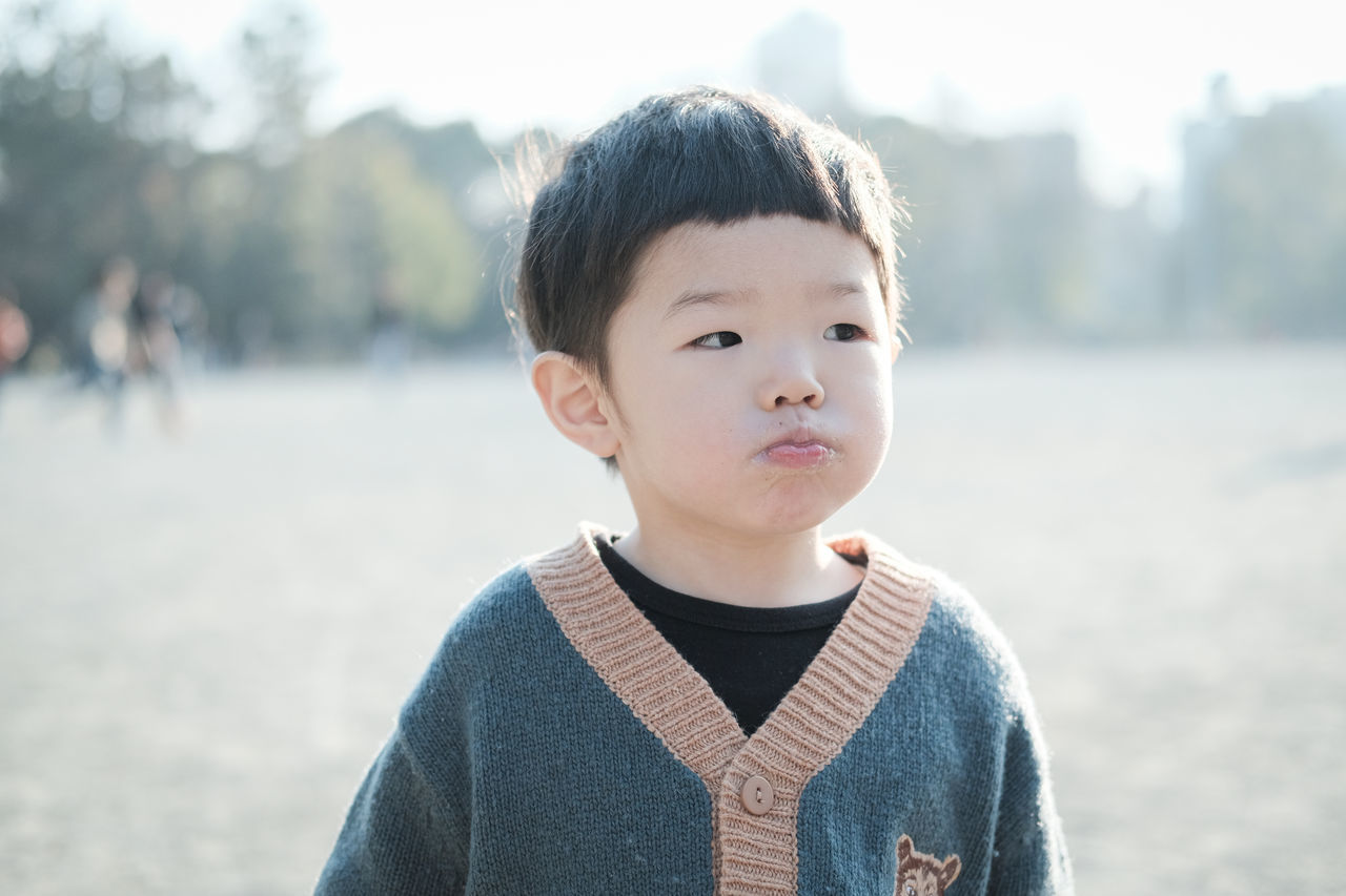 focus on foreground, one person, portrait, child, boys, childhood, front view, headshot, males, men, casual clothing, real people, lifestyles, day, looking at camera, outdoors, leisure activity, innocence, contemplation