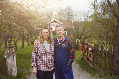 Portrait of a smiling couple standing against trees