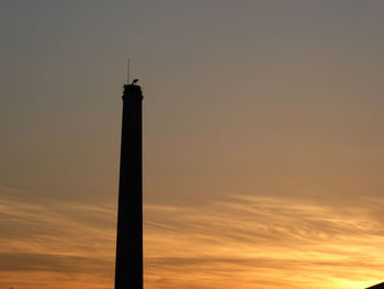 Silhouette tower against sky during sunset