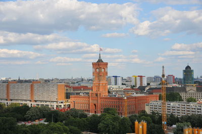 Buildings in city against cloudy sky