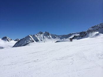 Scenic view of snowcapped mountains against clear blue sky