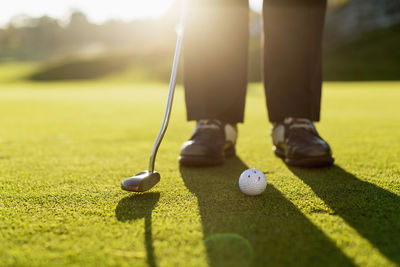 Low section of senior woman putting green on golf course