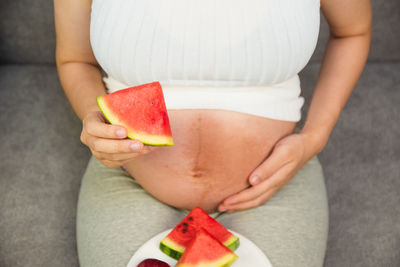 Midsection of woman holding fruit