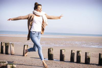 Full length of woman on beach against sky