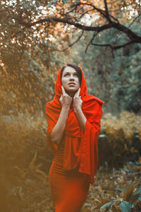 Portrait of beautiful young woman standing on land