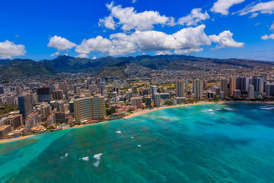 High angle view of townscape by sea against sky