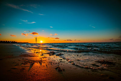 Scenic view of beach against sky during sunset