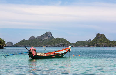 Boat moored on sea against sky