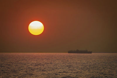 Scenic view of sea against orange sky