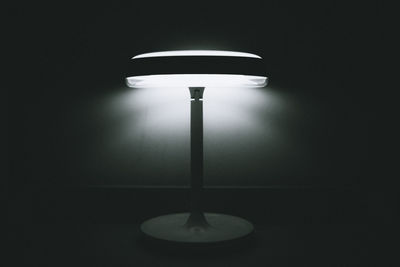 Low angle view of illuminated lamp against black background