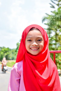 Portrait of smiling girl in red hijab