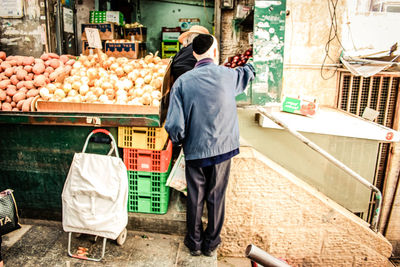 Rear view of man standing at market