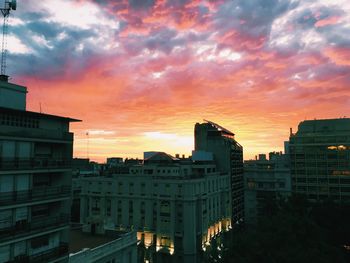 Buildings against cloudy sky at sunset