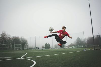 Woman playing soccer ball on field