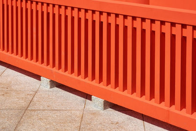 Shadow on footpath against wooden fence in building