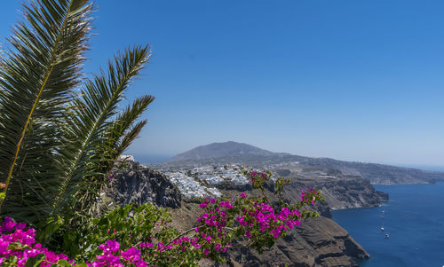 Scenic view of sea and mountains against blue sky