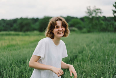 Happy cheerful teen girl with pronounced face dancing in outdoors.