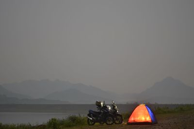 People on field against mountain range against clear sky