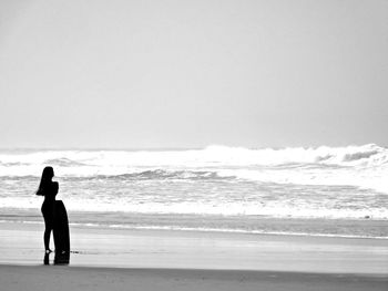 People on beach against clear sky