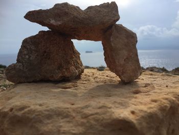 Rock formation on beach against sky