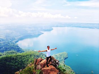 Man standing on rock looking at view of sky