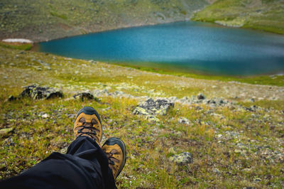 Traveler resting on a mountain plateau. pov view, legs close up on the background of mountain