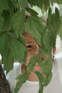 Close-up portrait of young woman with leaves