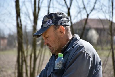 Portrait of young man looking away while standing outdoors