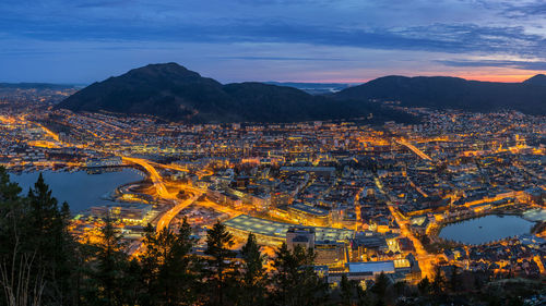 High angle view of illuminated city against sky at sunset