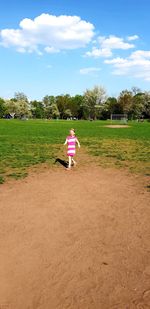 Rear view of woman on field against sky