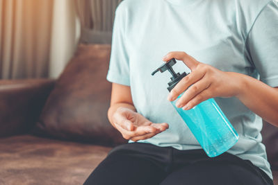 Midsection of man holding while sitting at home