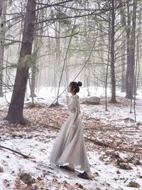 Side view of woman walking in forest during winter