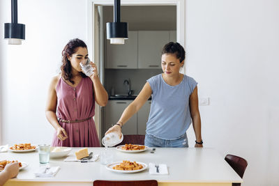 Women serving meal spending time at home together