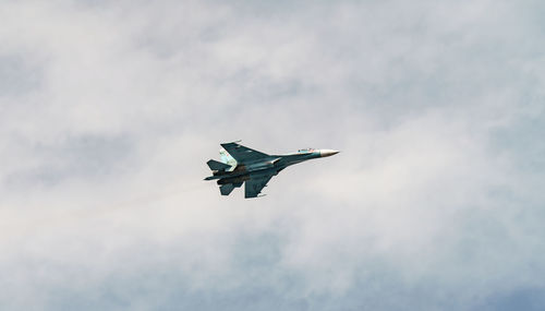 Low angle view of airplane flying against sky