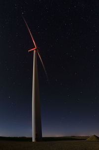Low angle view of windmill on field against sky at night