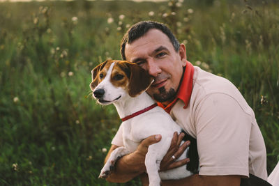 Portrait of a man playing with his jack russell dog in the park.