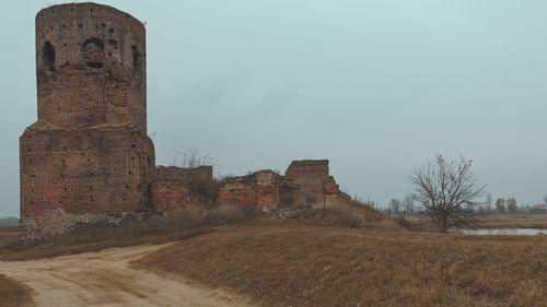 Old building on field against clear sky