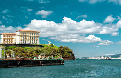 Boat entering vieux port against cloudy sky