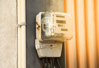 Close-up of telephone booth against wall