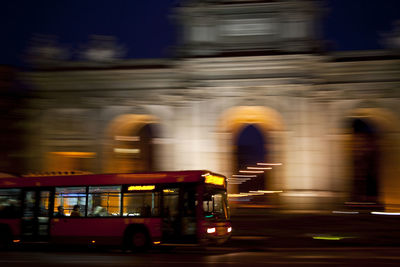 Public transport bus circulating in front of the puerta de alcalá in the city of madrid